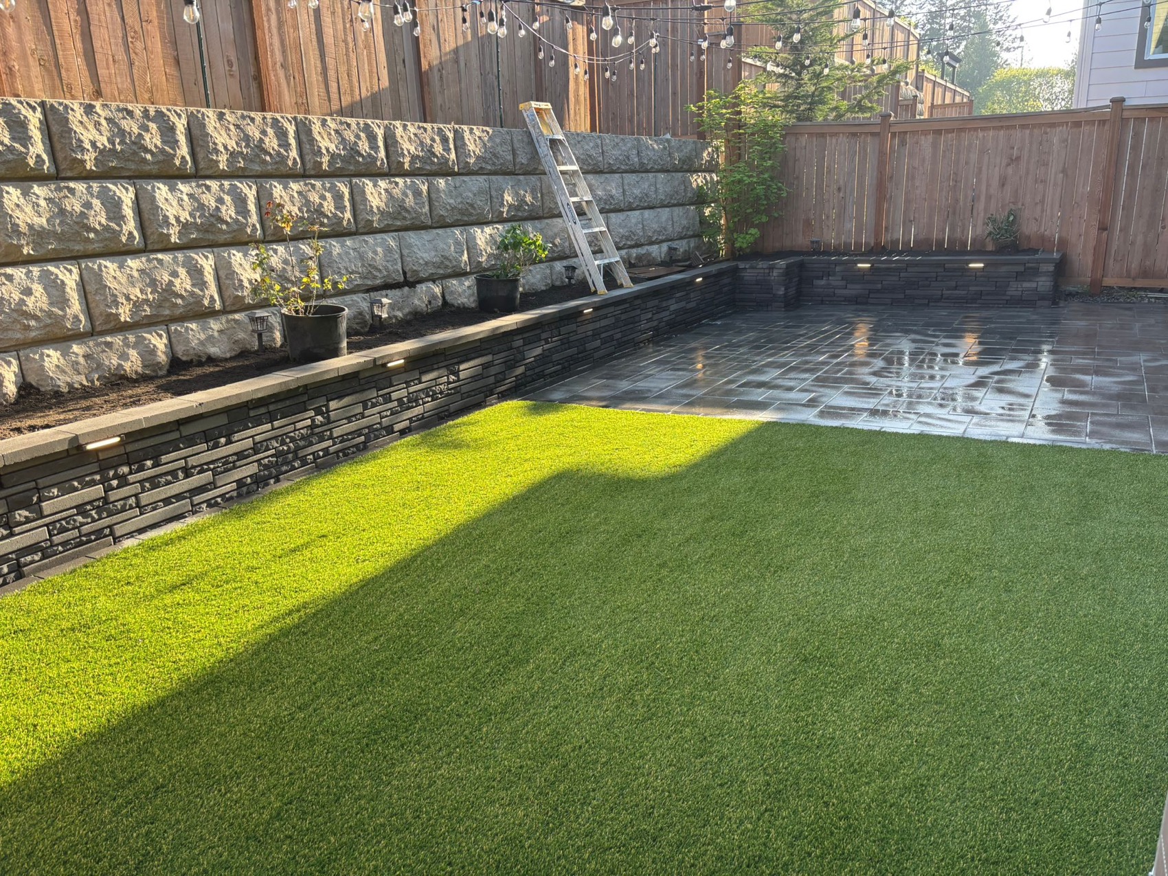 Backyard retaining wall, turf, patio, and landscape lighting